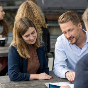 Image of consultants sitting at a table and talking outside