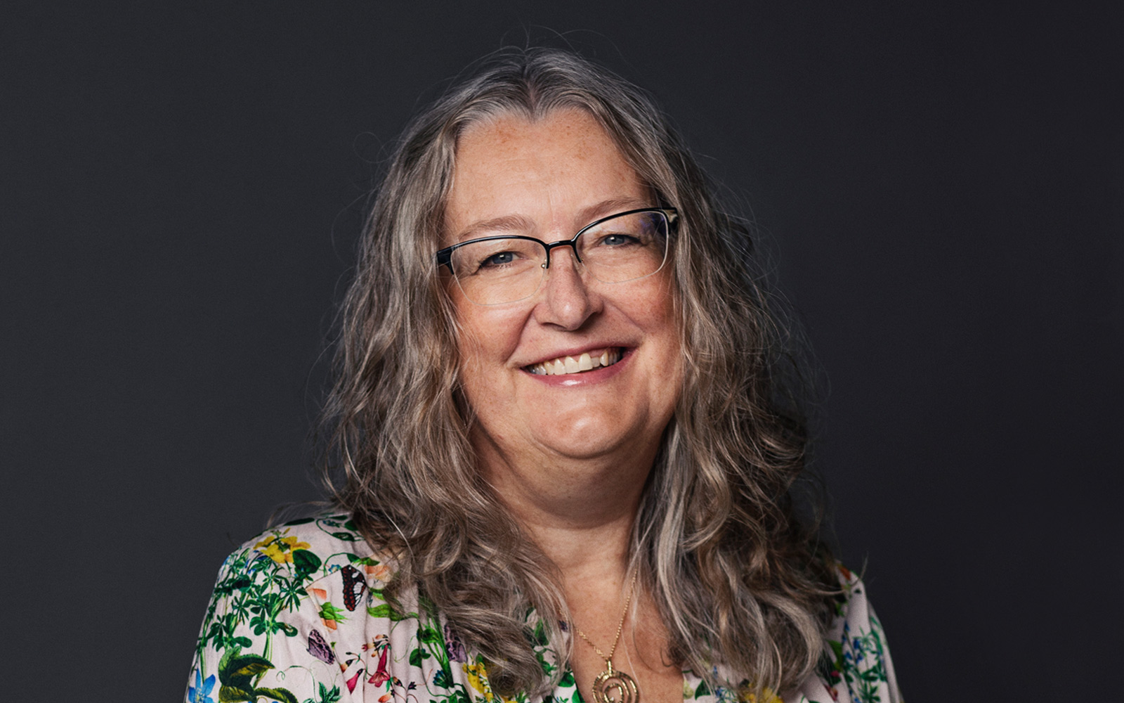 Ellen Breddam from Plougmann Vingtoft on dark grey background